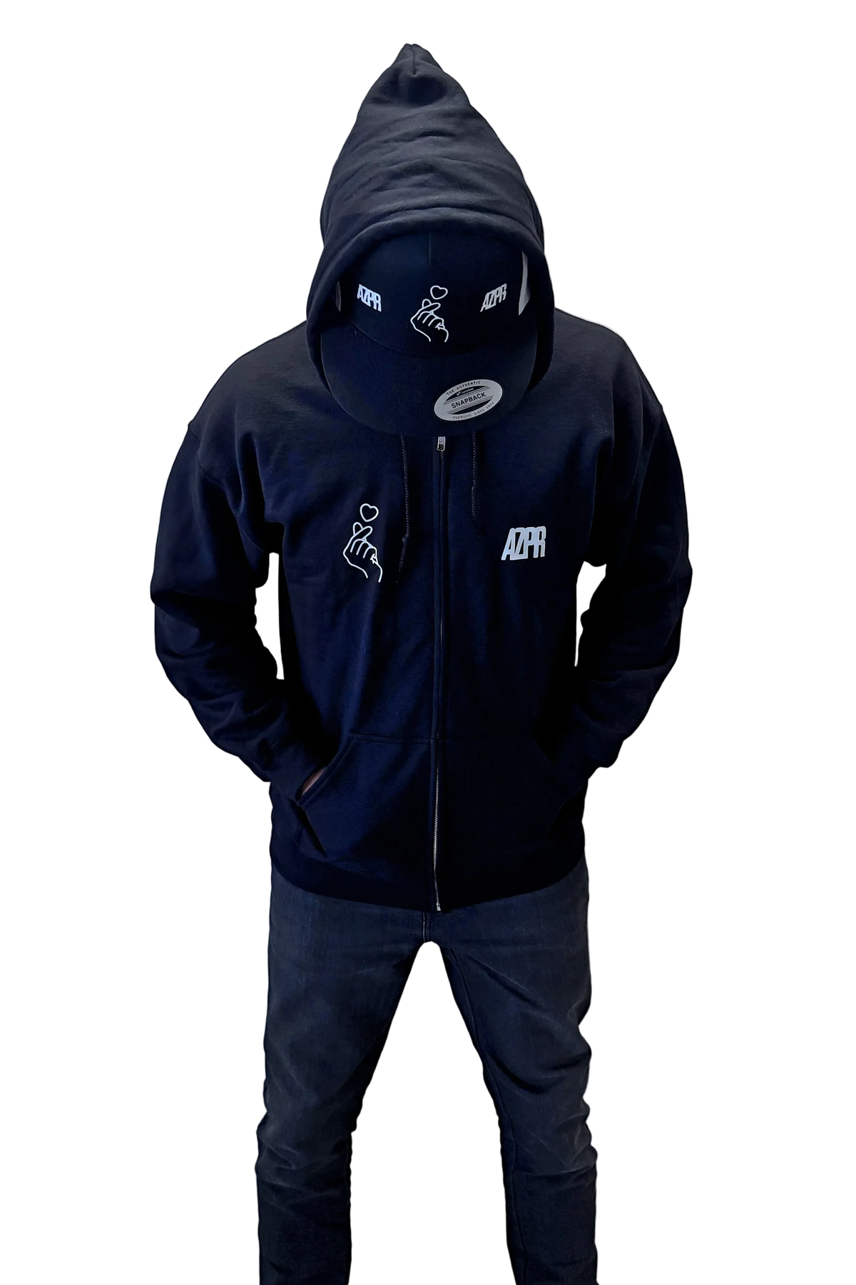 A person wearing a black AZPR zipped hoodie with white graphic prints on the chest and hood, paired with dark gray pants and white sneakers.